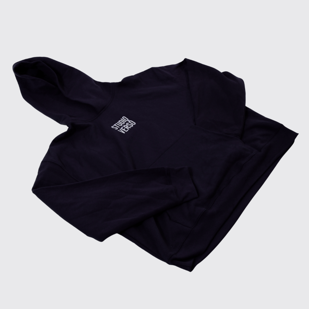 Navy hoodie with stacked embroidered Studio VERSŌ logo on the chest